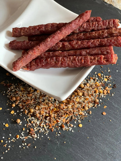 Hot Beef Jerky Sticks served on a plate with spices